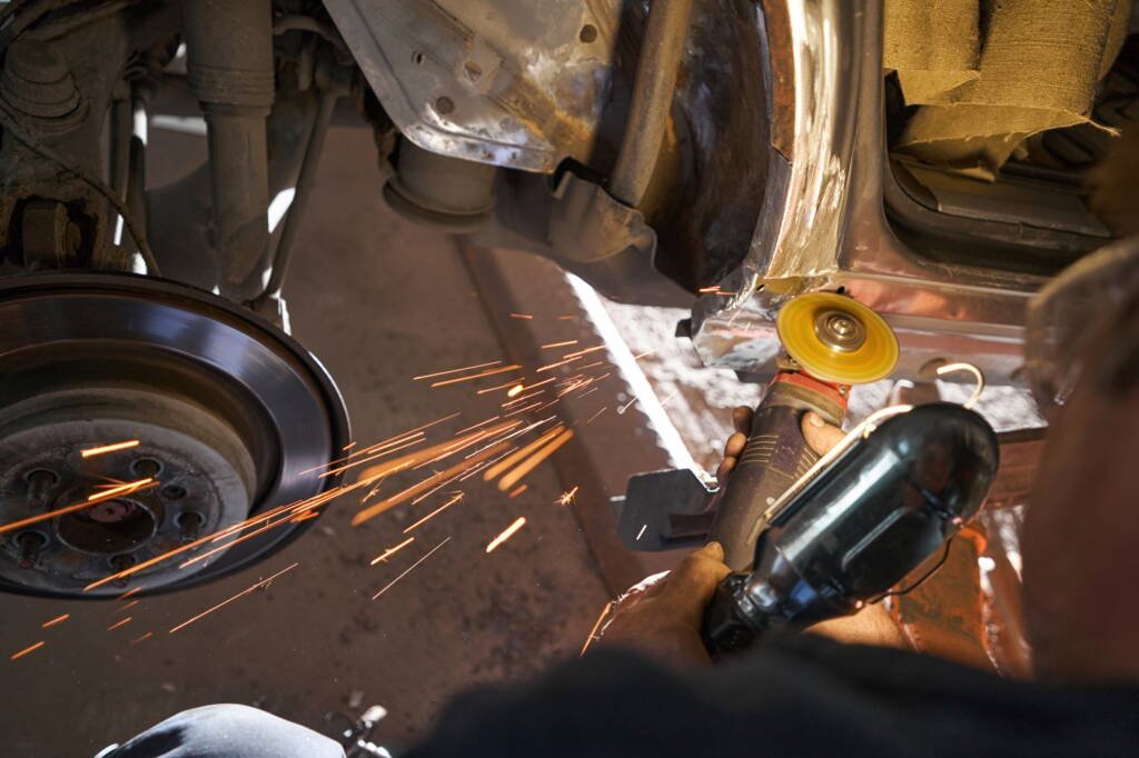 Male repairing car and working with tool
